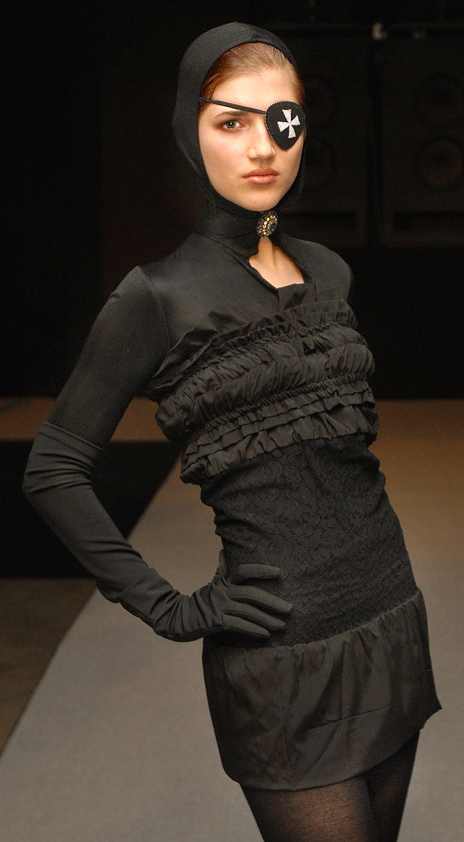 Catwalk model Clara presents an avant-garde black evening gown with a hood by the German fashion designer Torsten Amft from the Fall / Winter 2008 - 2009 trend collection during the Fashion Week Berlin. Accessories serves as an eye patch with Templar cross. photo: M.Wittig